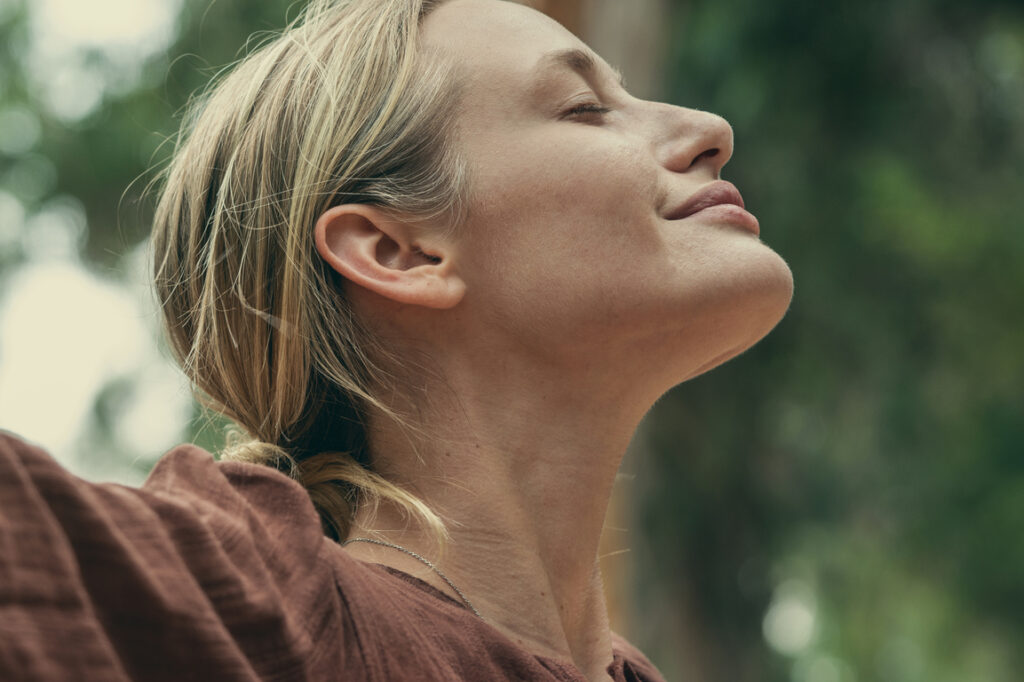 Woman raising her arms and embracing nature